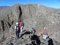 20-peak__4484_in_distance-looks_like_group_going_over_cliff,gloves_good_idea_since_sharp_rock