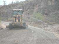 27-grader_spreading_gravel_with_a_wash_on_the_right_side_of_the_road