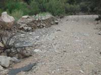 111-wash_to_left_of_road-lots_of_rocks_moved_across_road