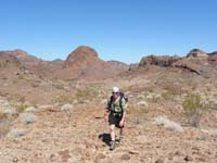 26-Bill_hiking_with_desert_scenery_and_Hoover_Dam_Bypass_bridge_in_distance