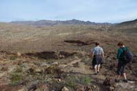 58-hiking_back-Kenny_leads-open_desert_scenery-parking_lot_one_mile_away