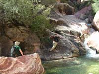 13-Dave_traversing_a_boulder_without_falling_in_the_water_with_Bruce_watching