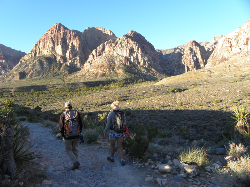 01-Ed_and_Jutta_starting_the_trail-Mescalito_is_red_capped_cone_mountain_towards_right_tucked_in_canyon