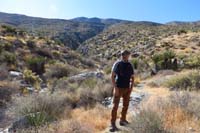 11-Brett_with_Trench_Canyon_in_background,we'll_hike_up_as_far_as_we_can,then_R_up_Waterworld_Cyn