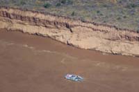 14-zoom_view_of_swift_flowing_river_with_river_rafter_and_cliff_erosion_from_1963