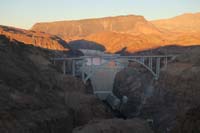 41-Hoover_Dam_and_bridge_with_Fortification_Hill_in_background,setting_sun_perspective