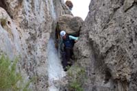 55-Cheryl_squeezing_under_chock_stone_to_start_rappel