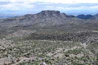 09-looking_back_to_Lonely_Pinon_Mountain,vehicle_parked_in_wash_in_center